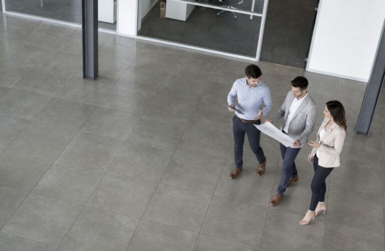 overhead look at group of 3 business people looking at document