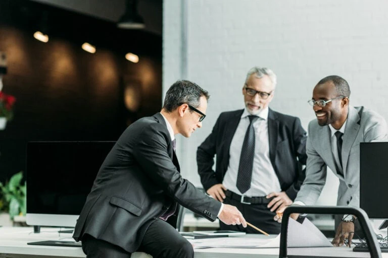 3 businessmen looking at documents in office