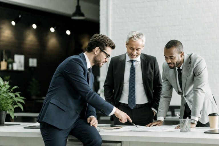 3 businessmen looking at documents in office