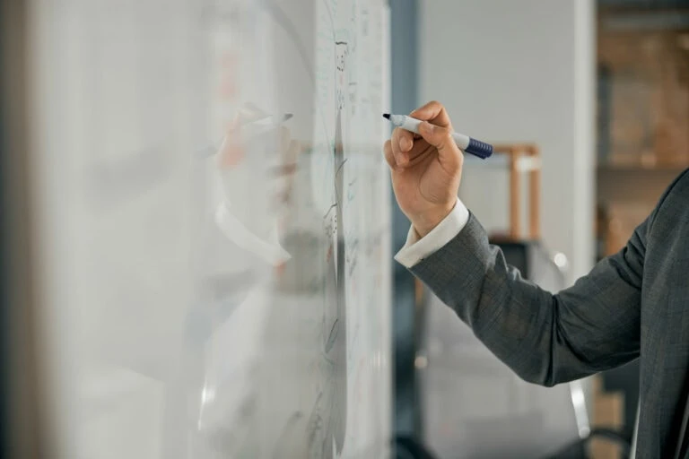 male hand writing on whiteboard