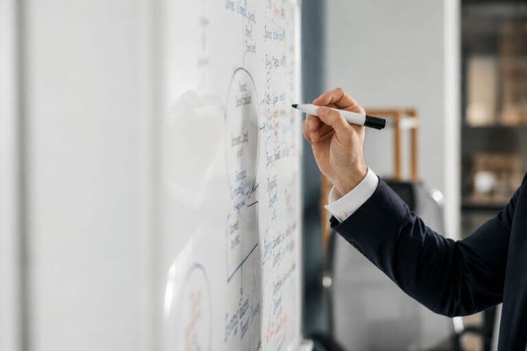 male hand writing on whiteboard